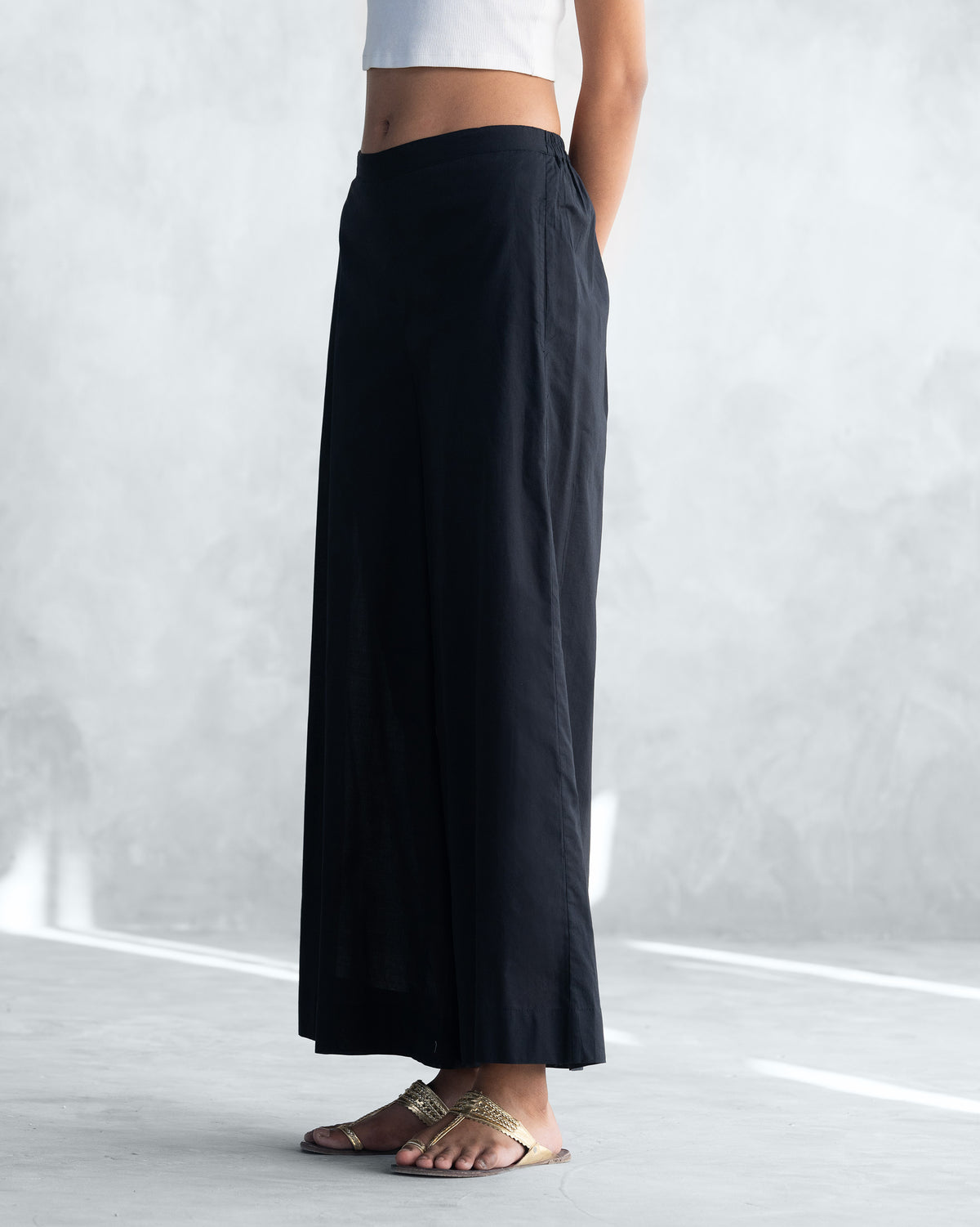 Side view of black Basic Pyjamas wide-leg trousers.