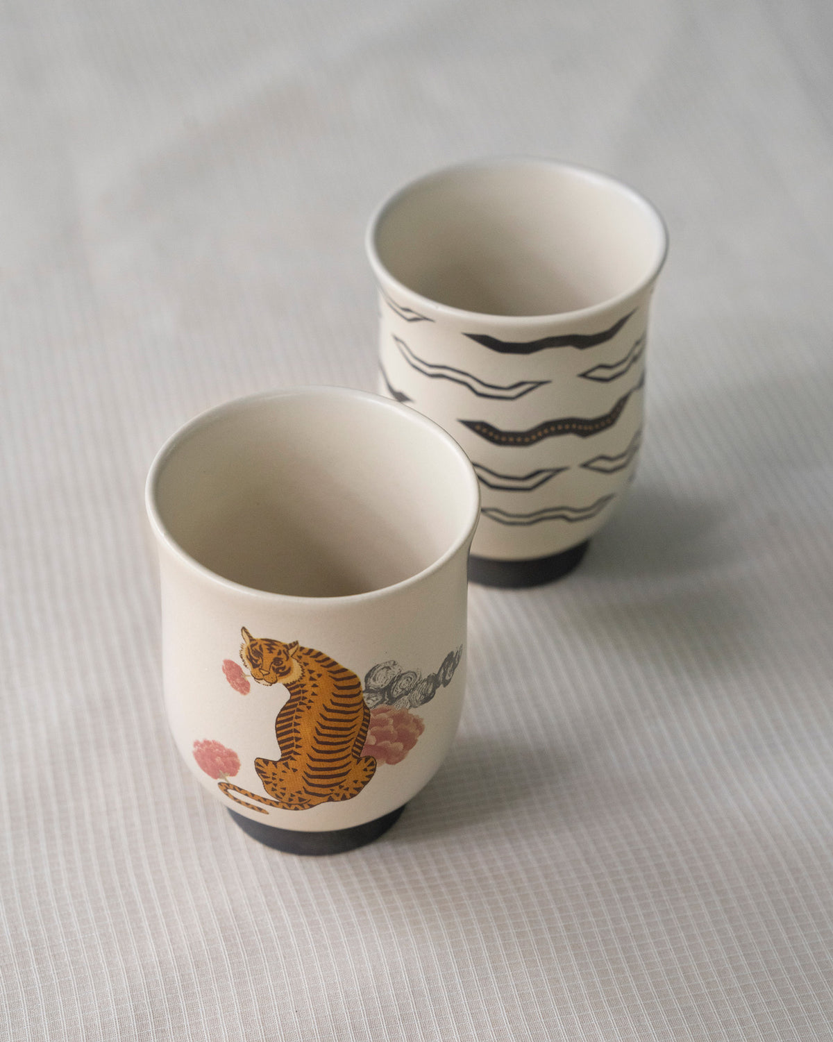 Sitara tea cups seen from above, with a tiger and black waves.