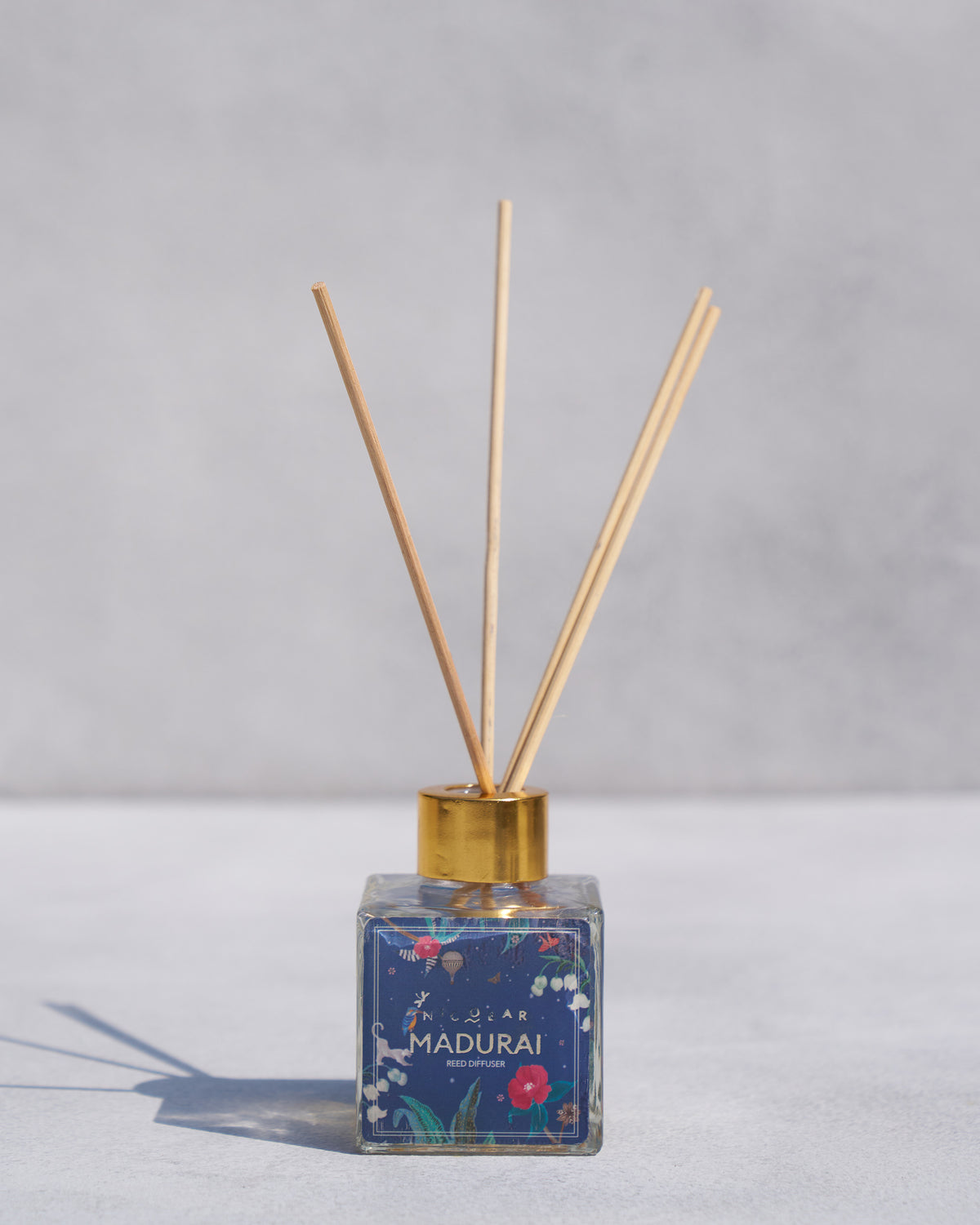 Madurai Reed Diffuser with reed sticks rising from its gold cap.