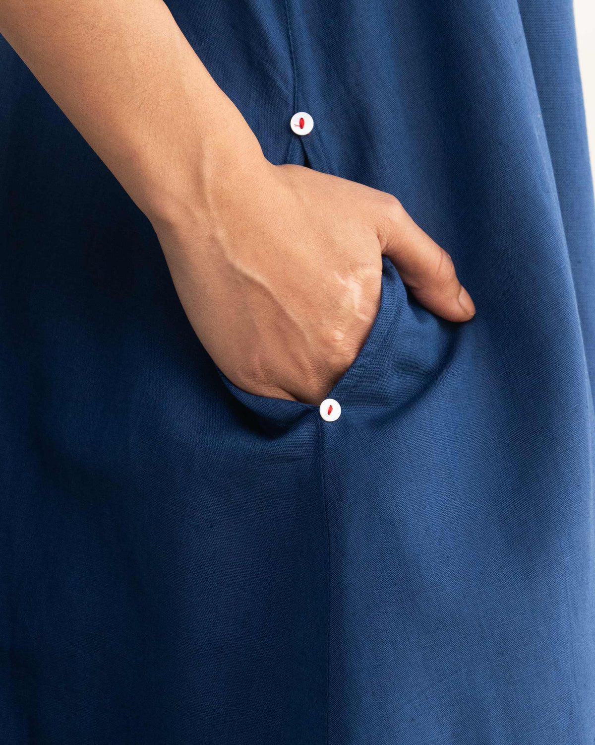 Close-up of a navy Double layer dress pocket with small buttons.