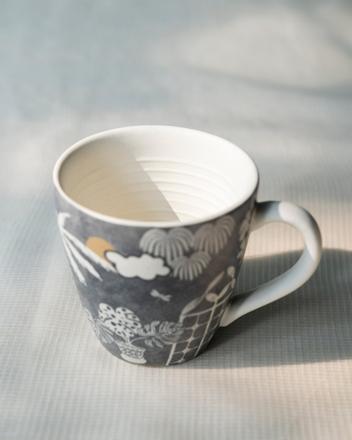Mandovi Palm Mug with a white inside and a palm and cloud print.