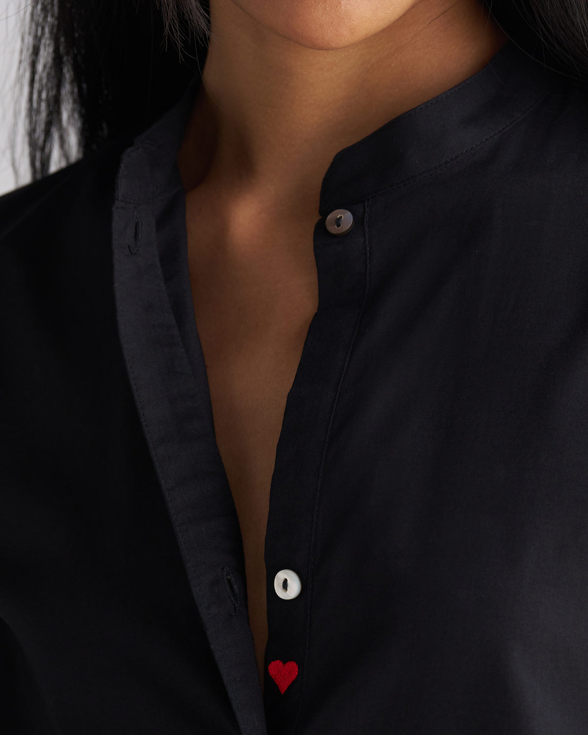 Close-up of the mandarin collar and red heart on a black long kurta.