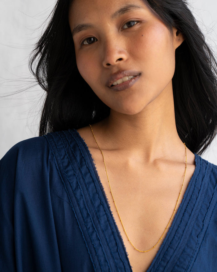 Person wearing medium Boondi Chain in gold.