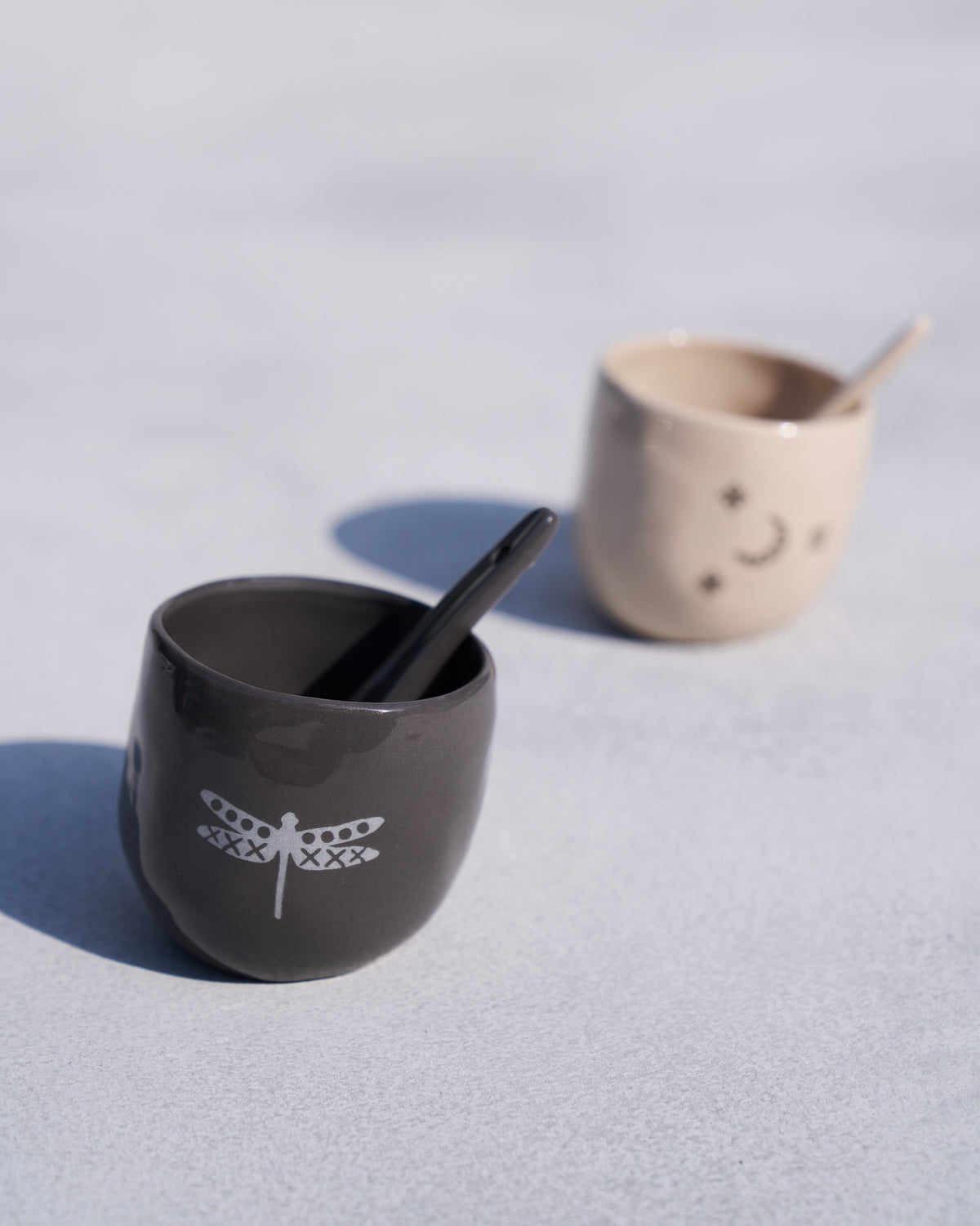 Charcoal Taramandal pot with a white dragonfly motif and spoon.