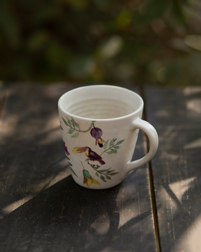 Nakano mug with birds and leafy branches printed around its side.