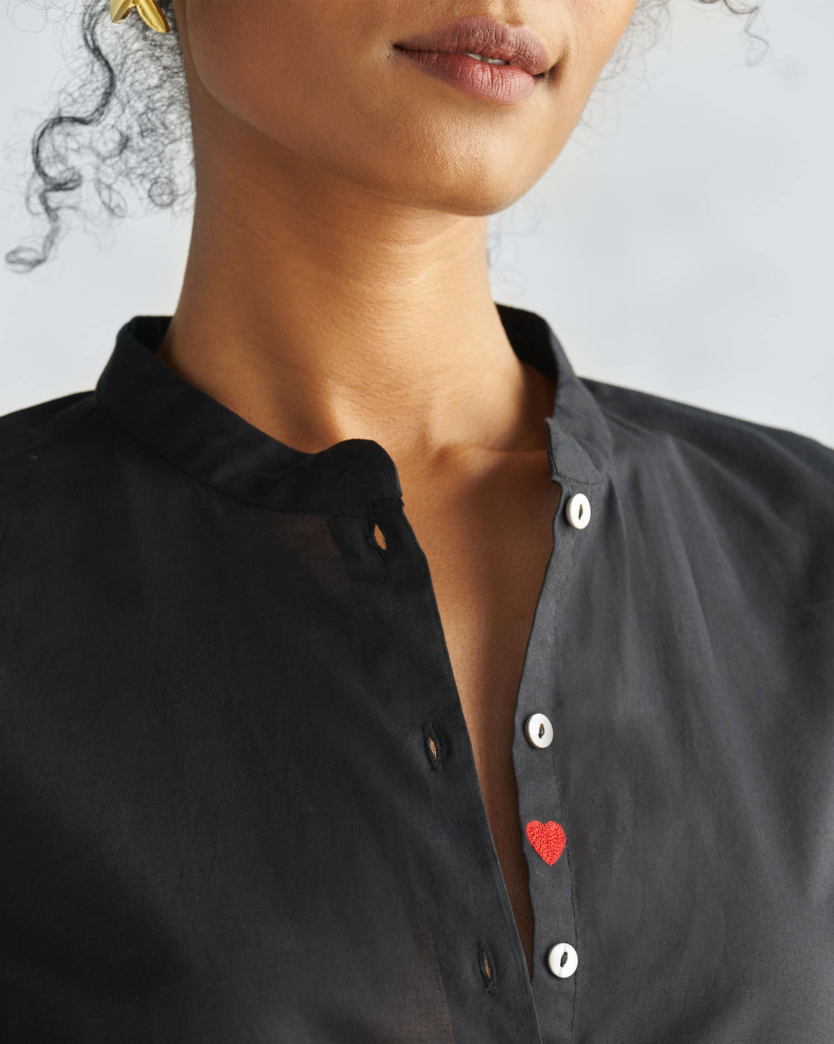 Black mandarin collar top with a heart on the placket.