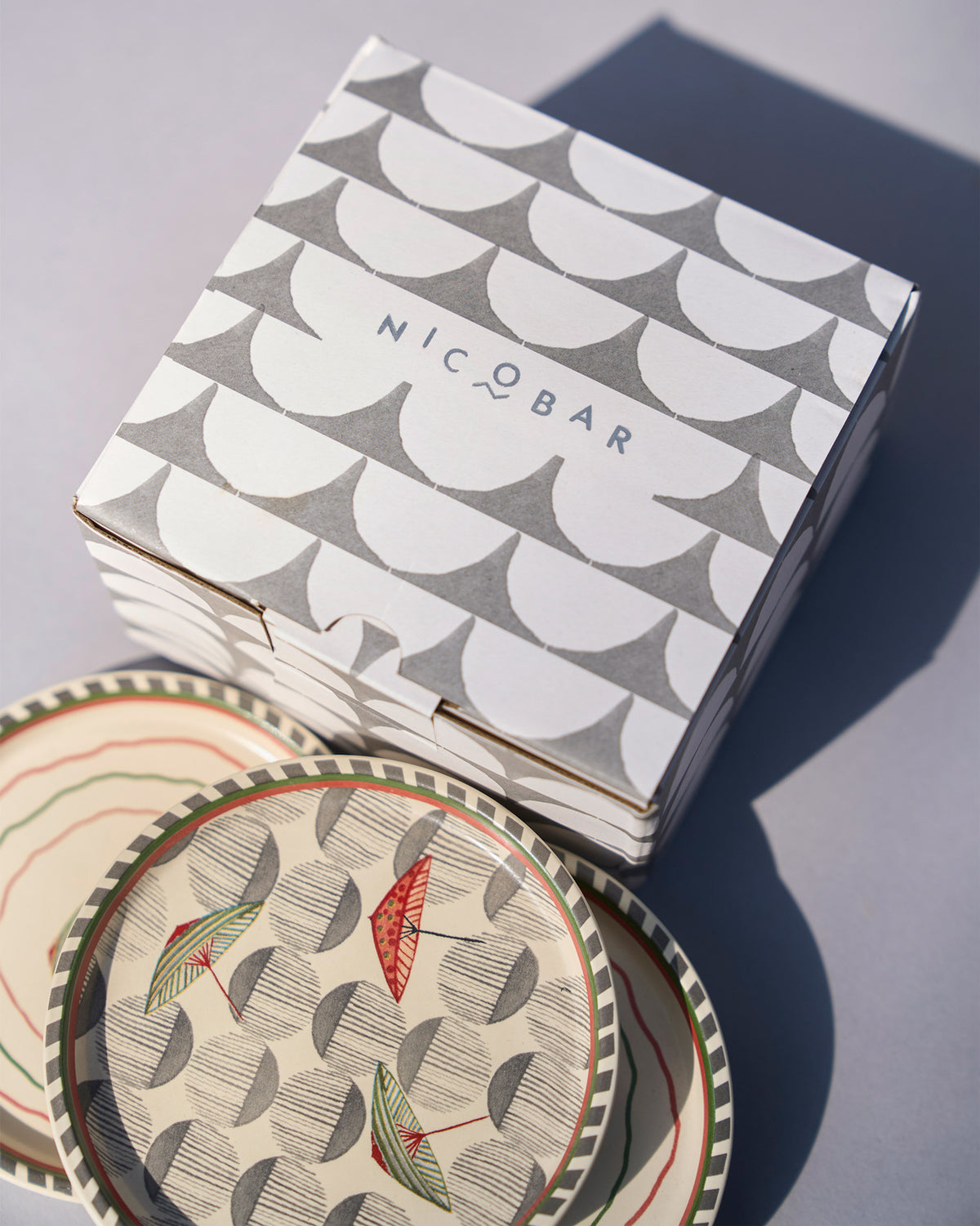 Tribe Coasters stacked beside a patterned gift box.