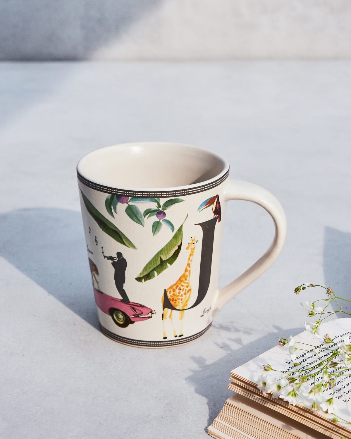 Jungle mug with a giraffe, toucan and leaves printed on it.
