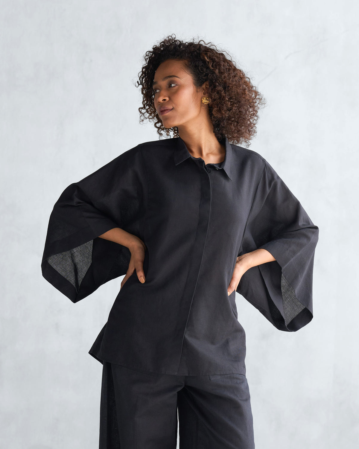Person wearing a black Drop armhole shirt with a concealed front placket.
