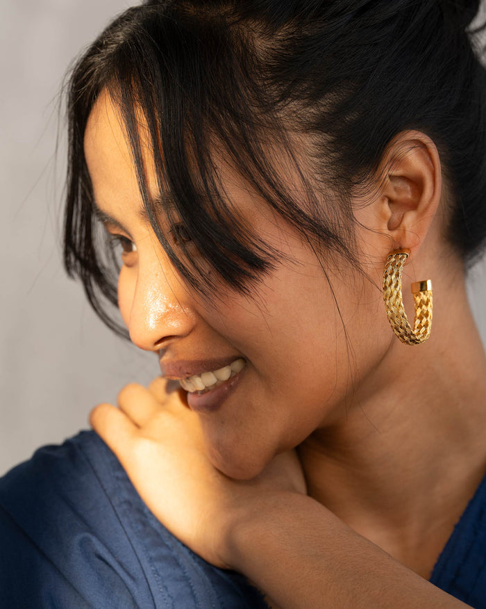 Side profile of Sea Shore Hoops with a braided gold texture on a person.