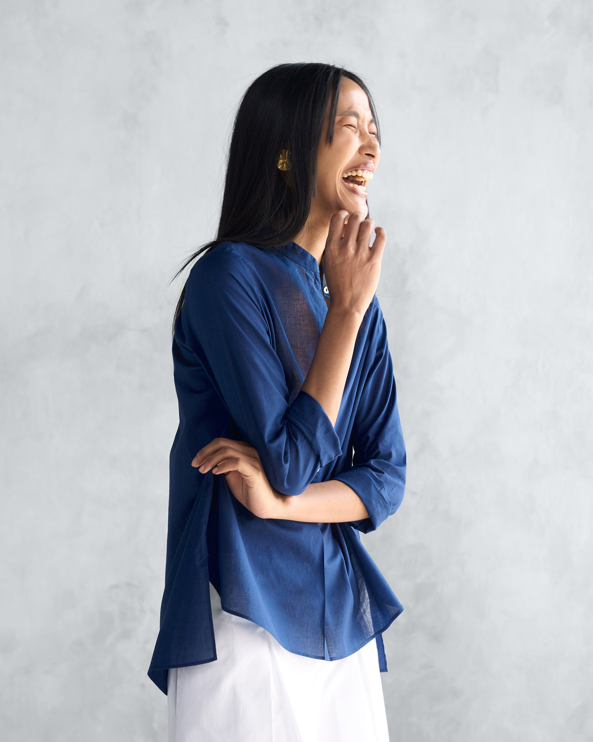 Side view of a navy mandarin collar top worn by a person.