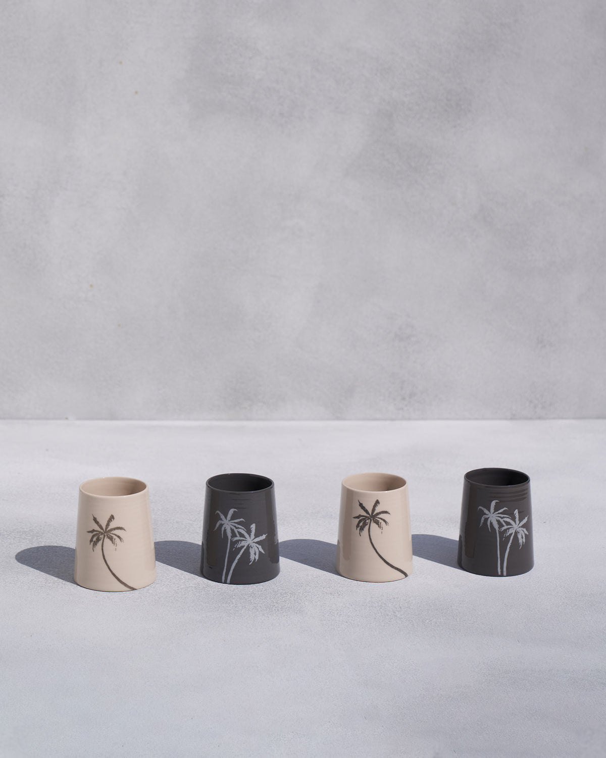 Four Swaying Palm Kulhars in a row, alternating cream and charcoal.