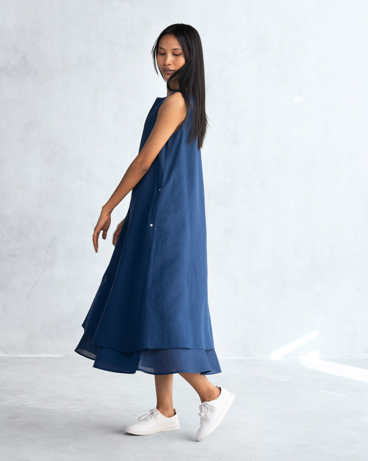 Side view of a navy Double layer dress with a layered hem.