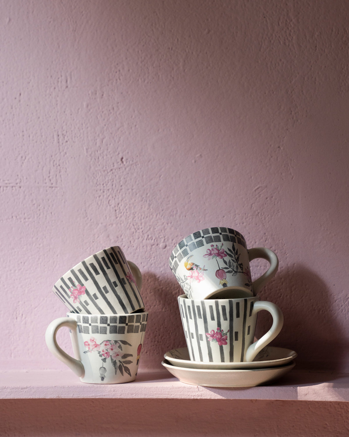 Nectar espresso mugs stacked to show floral and vertical stripe print variants.