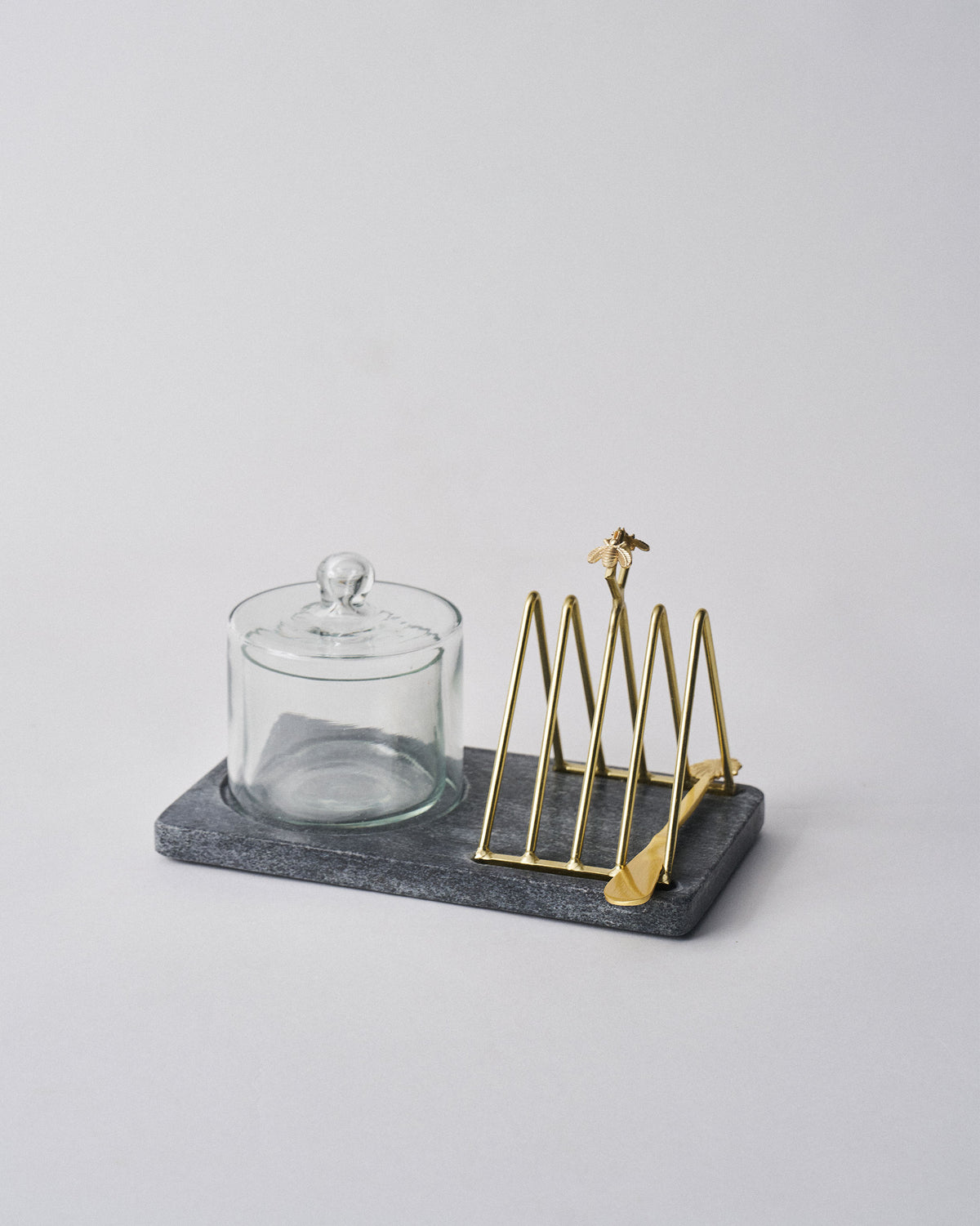 Black and gold Mahi breakfast tray with glass dish and toast rack.