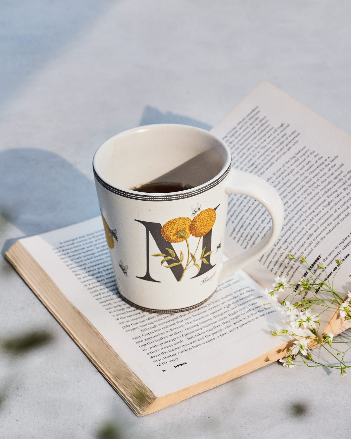 The Machli Mug filled with coffee on an open book.