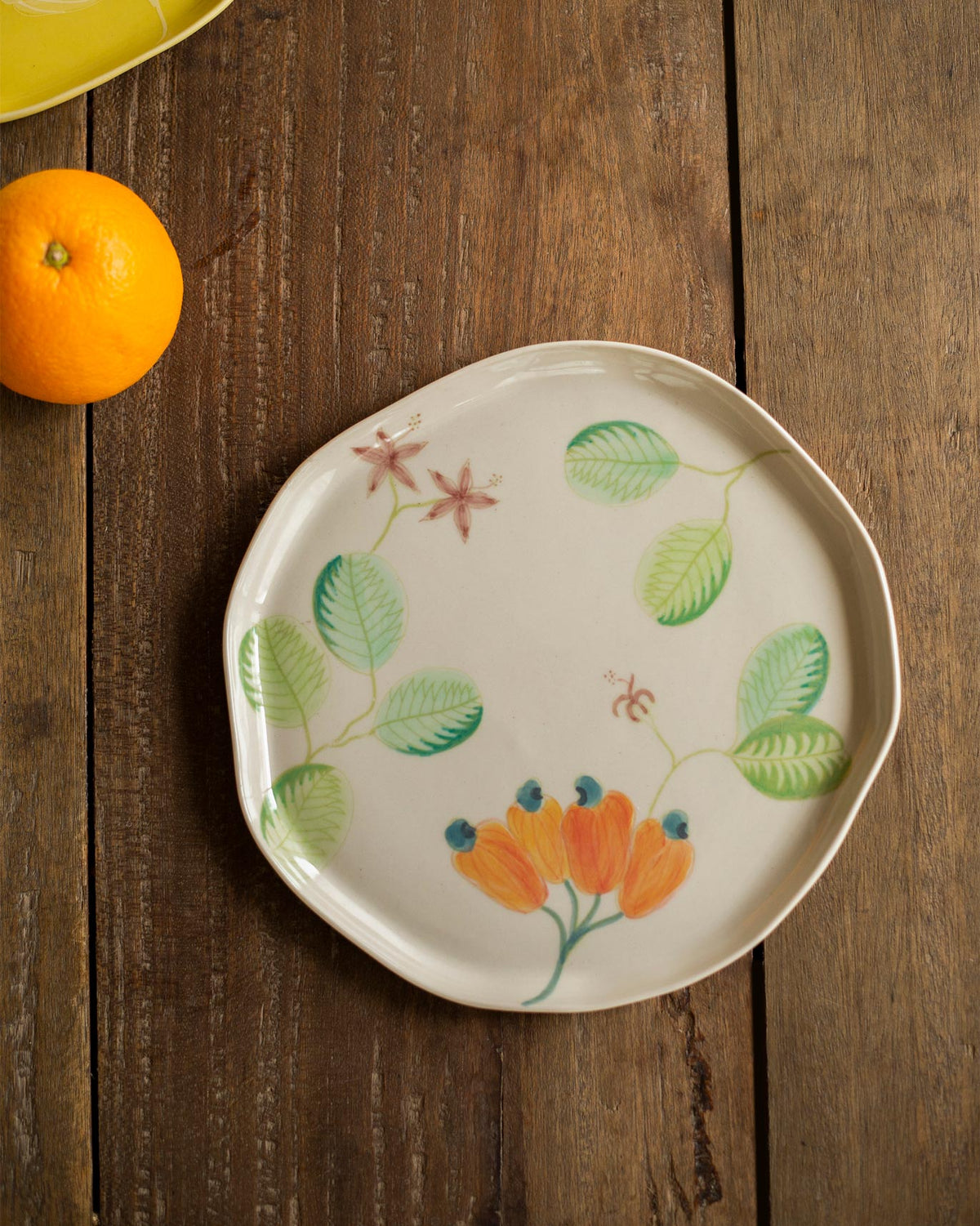 Mandovi quarter plate with orange flowers and green leaves painted on cream.