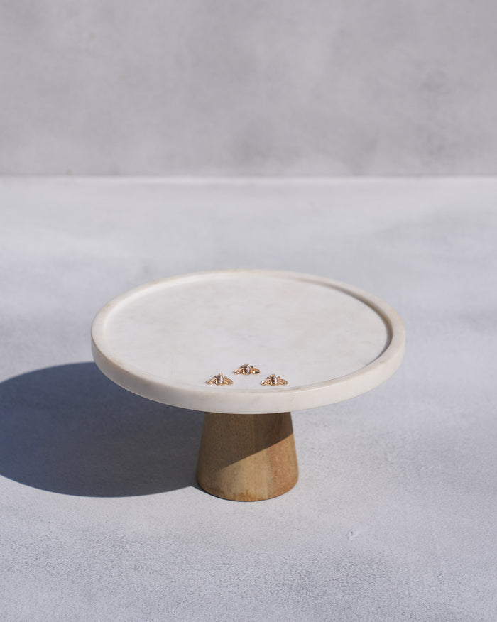 Firefly white cake stand with a wooden base and three small gold bees.
