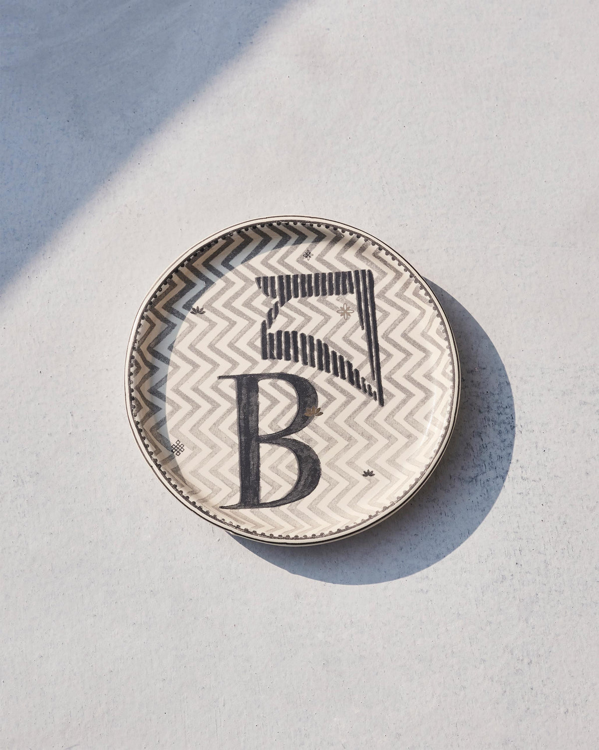 Akshar Coaster at an angle, showing its beaded rim and letter B.