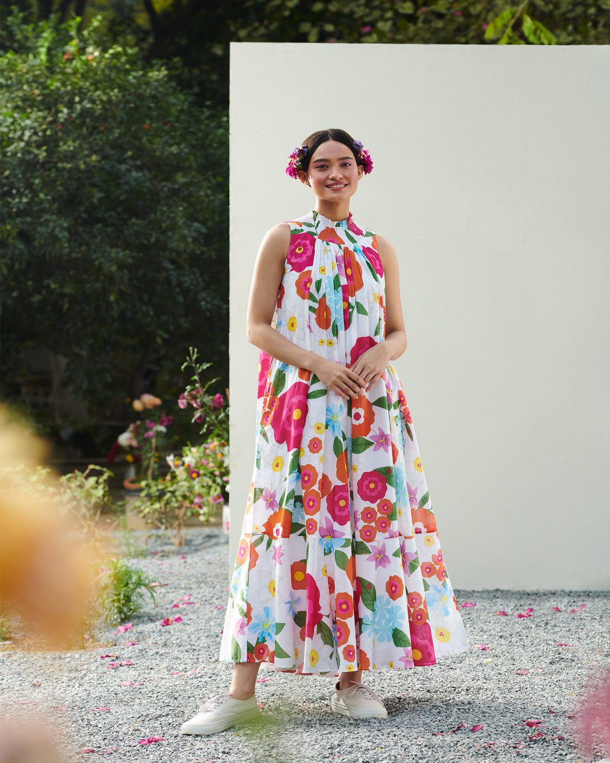 Person wearing a smocked neck dress in a white bold floral print.