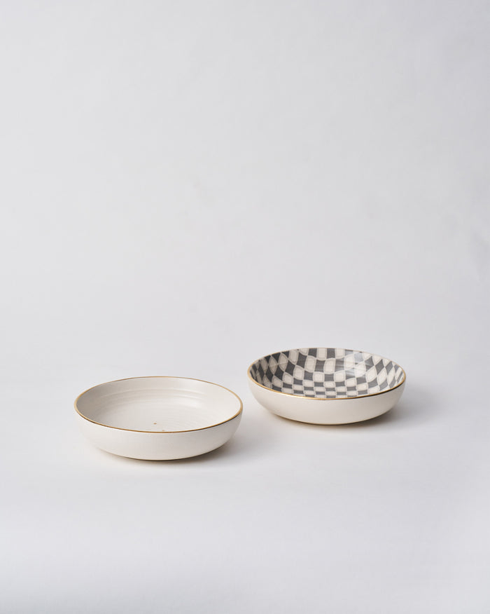 Pair of Fez Shallow Bowls with cream and checkered interiors and gold rims.