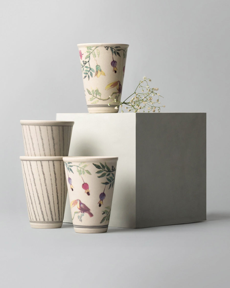 Kulhars stacked against a grey block with a sprig of flowers