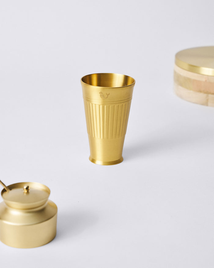 Brass Dariya lassi glass with a ribbed body and flared base.