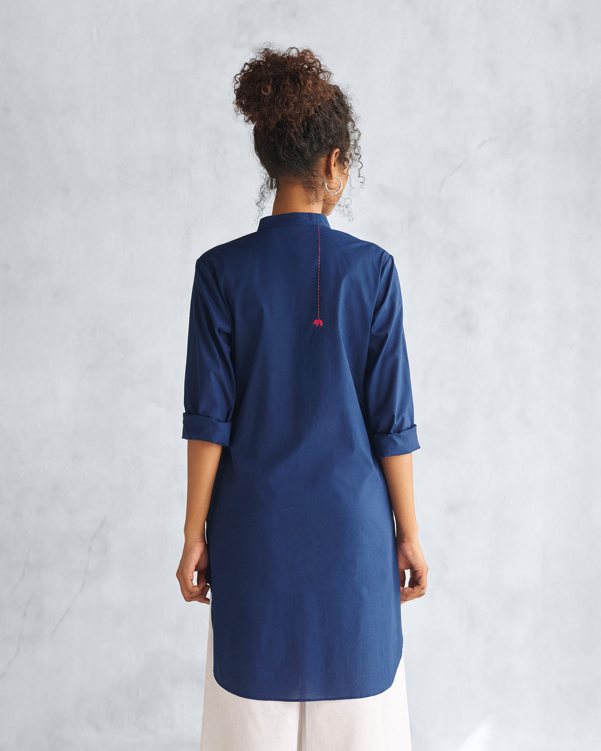 Back of a navy mid-length kurta with a red elephant embroidery.