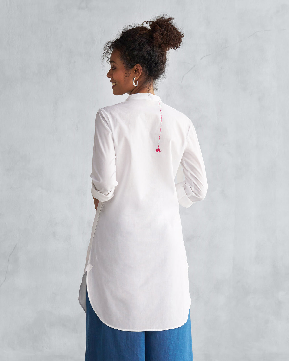 Back of a white mid-length kurta with a red elephant motif.