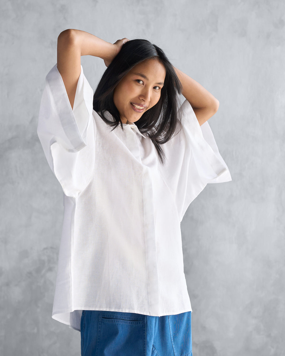 Person wearing a white Drop Armhole Shirt with a boxy oversized fit.