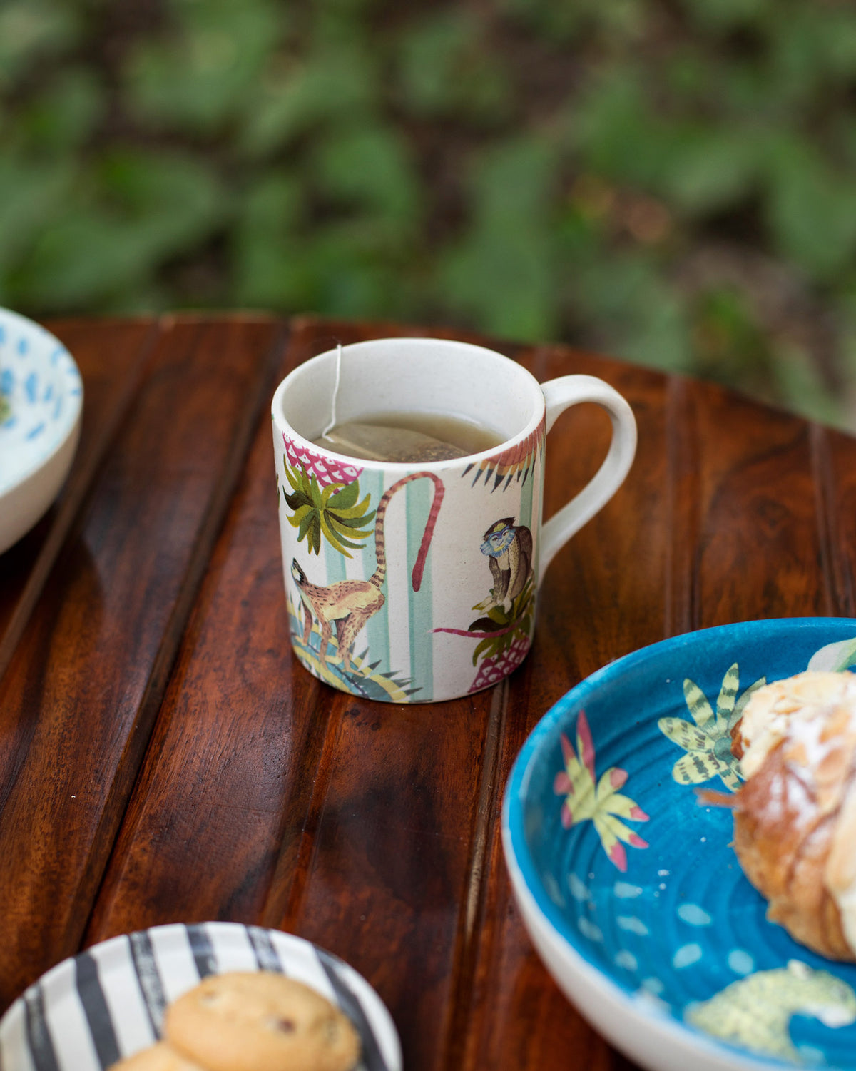 Ivory Mahi Mug filled with tea on a wooden table.