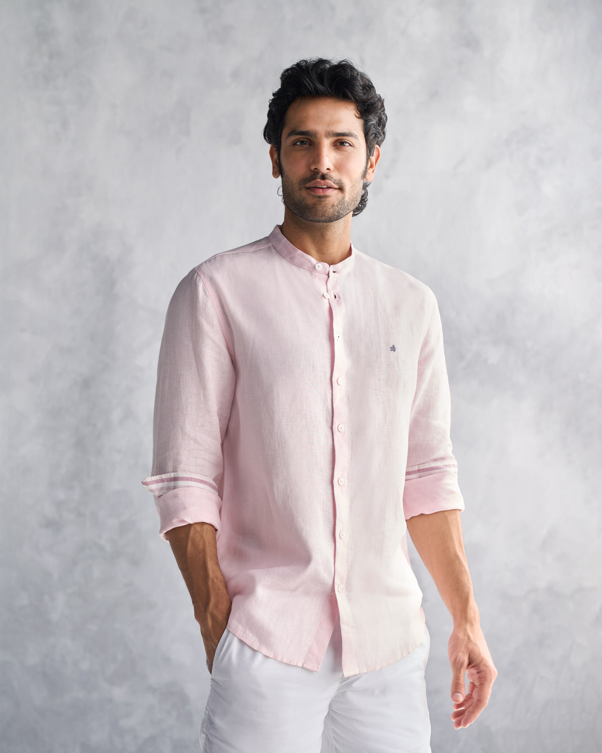Side view of a pink Nawab Shirt with rolled sleeves and striped cuff lining.