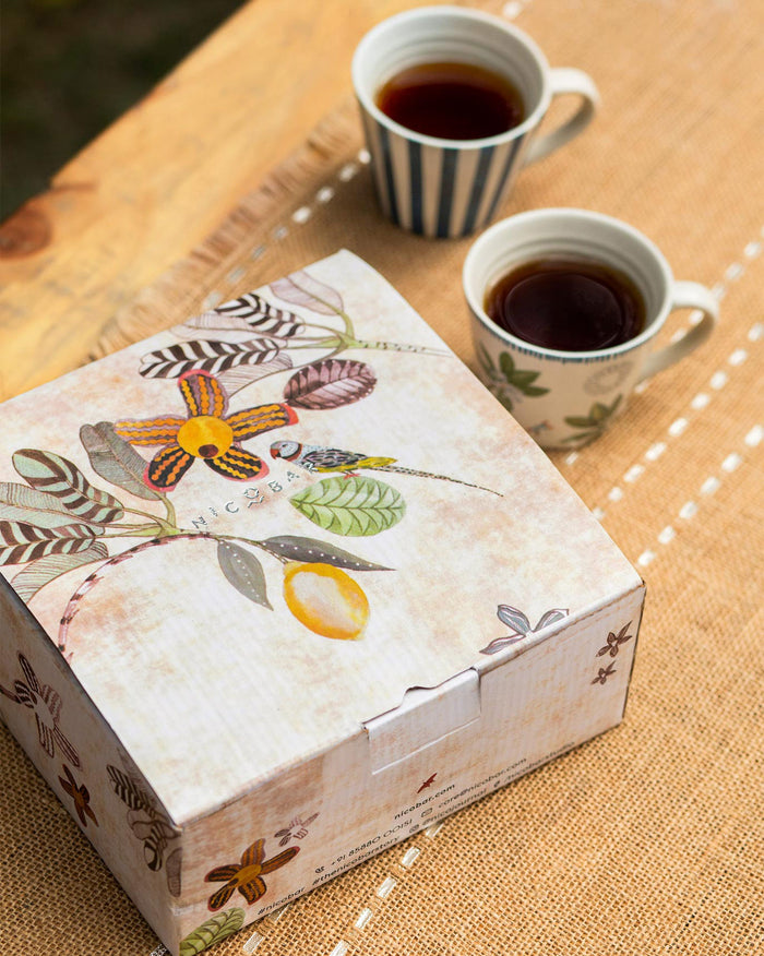 Two mugs beside the gift box