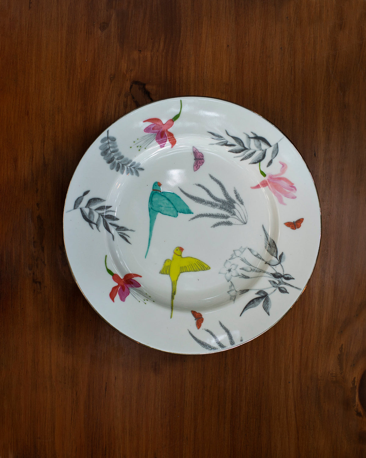 Botanical quarter plate with birds, flowers and leaves, seen from above.