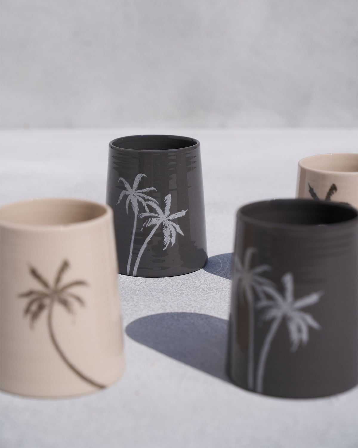 Close-up of Swaying Palm Kulhars showing palm tree motifs in cream and charcoal.