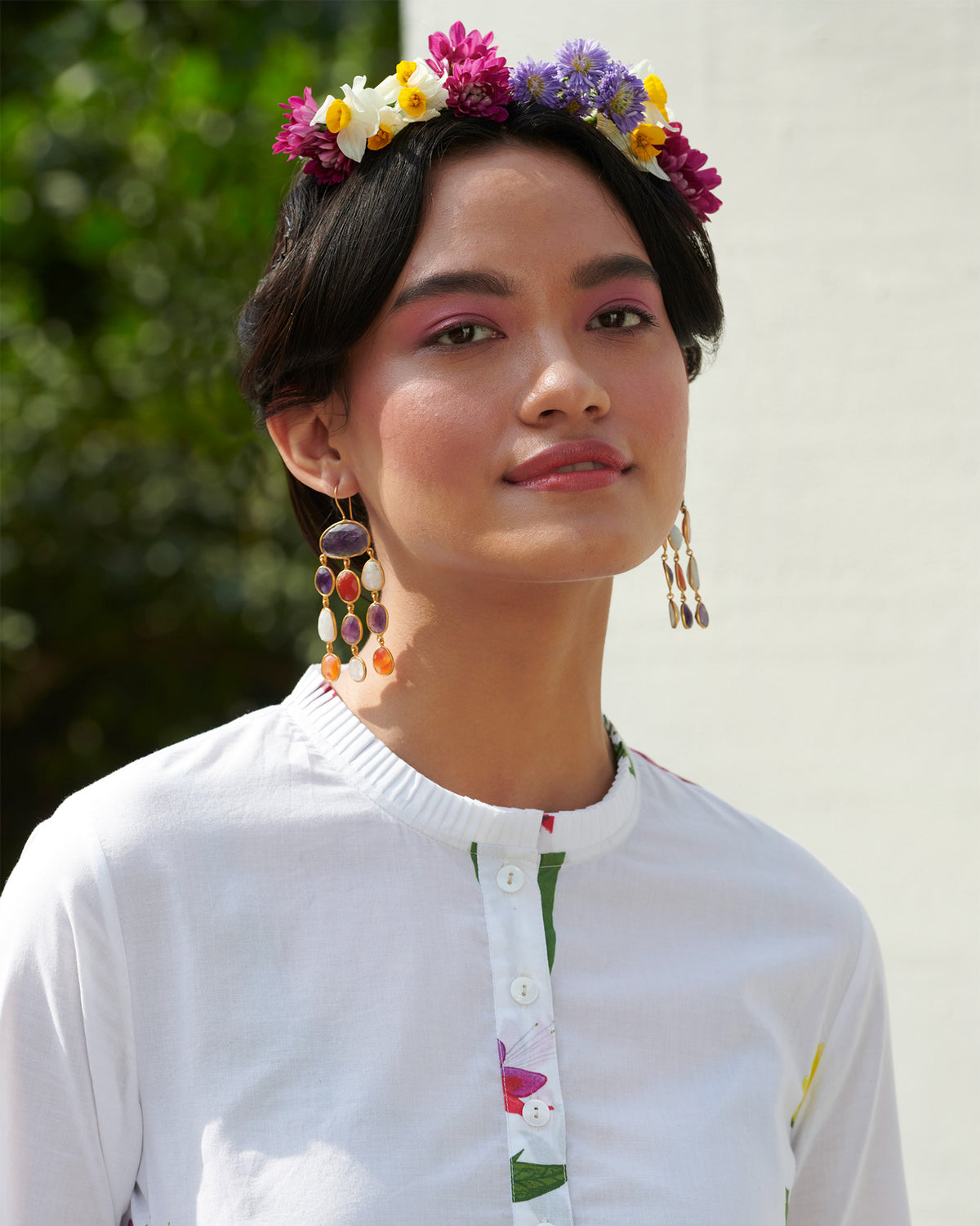 Close-up of a button placket on a white pleat-front kurta with floral print.