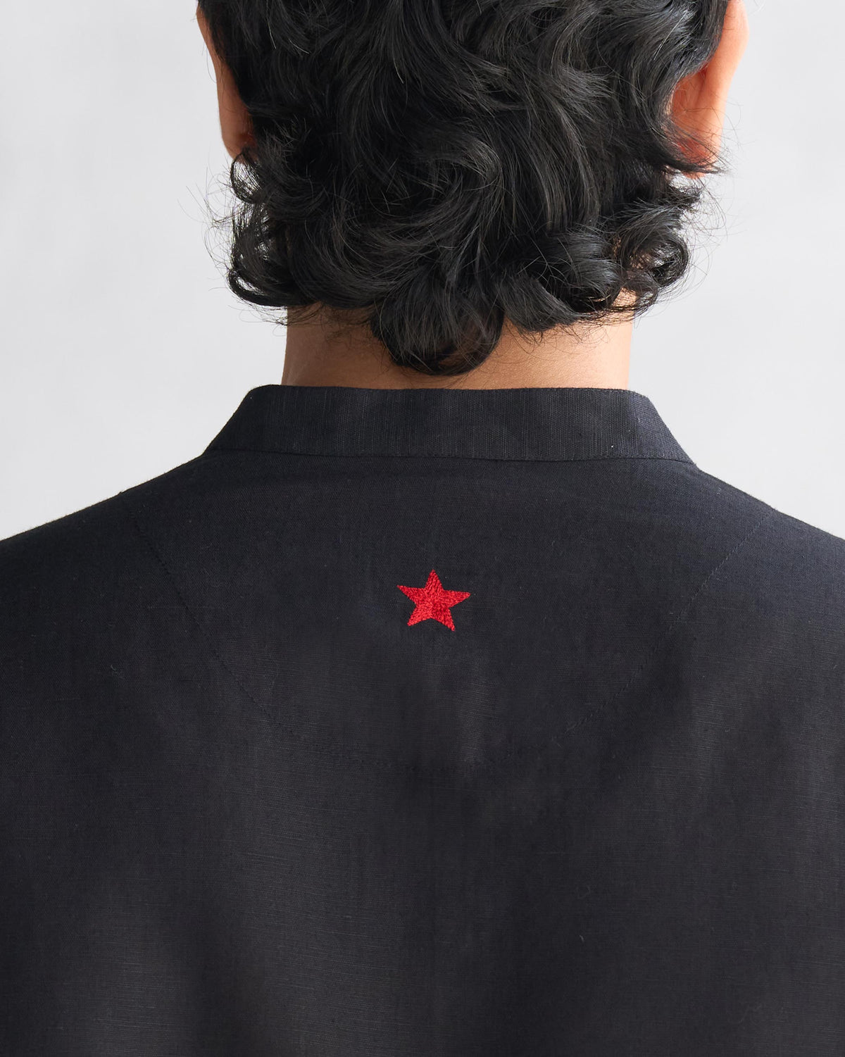 Close-up of a red star on the back of a black Chandni Chowk kurta.