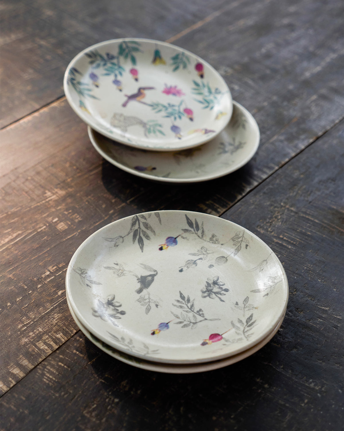 Nakano tapas plates in grey and colour prints with birds and hanging flowers.