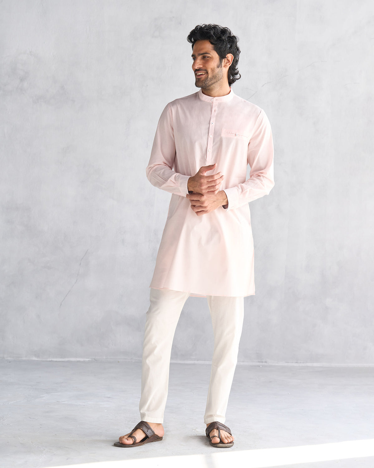 Pink Pondicherry kurta worn full length with cream trousers.