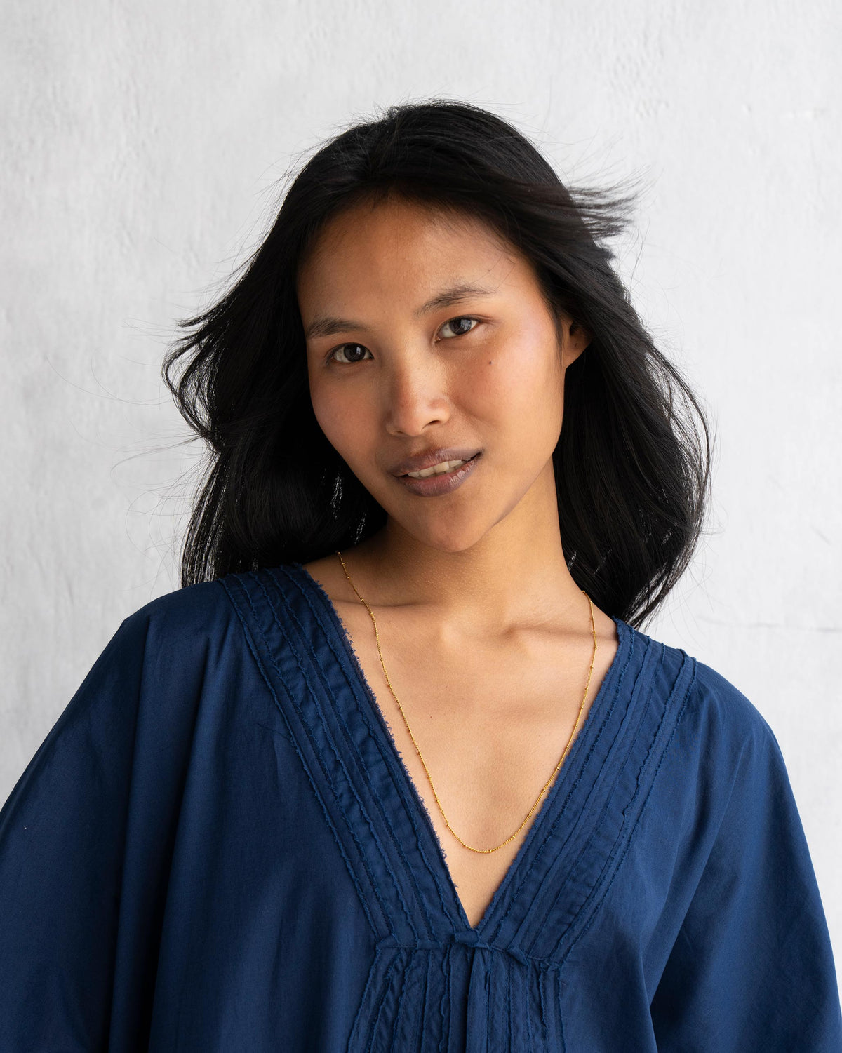 Person wearing medium Boondi Chain in gold, shown from the chest up.
