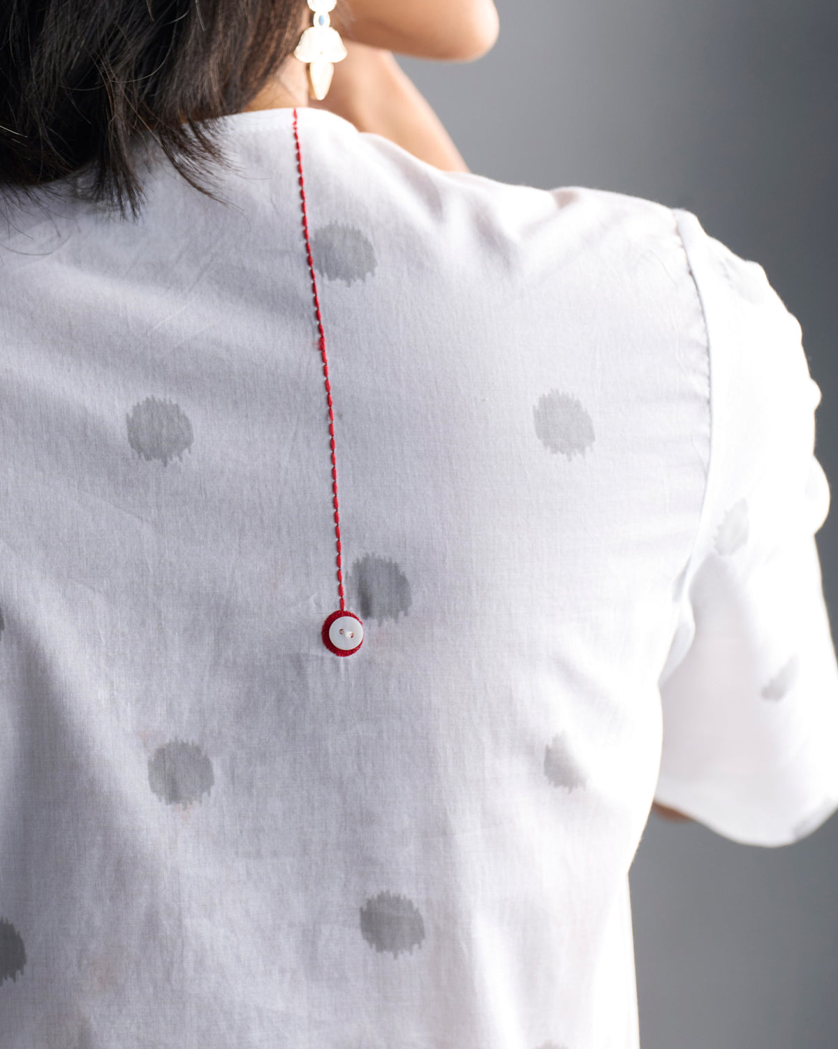 Close-up of the kurta back showing a red stitch line ending in a button.