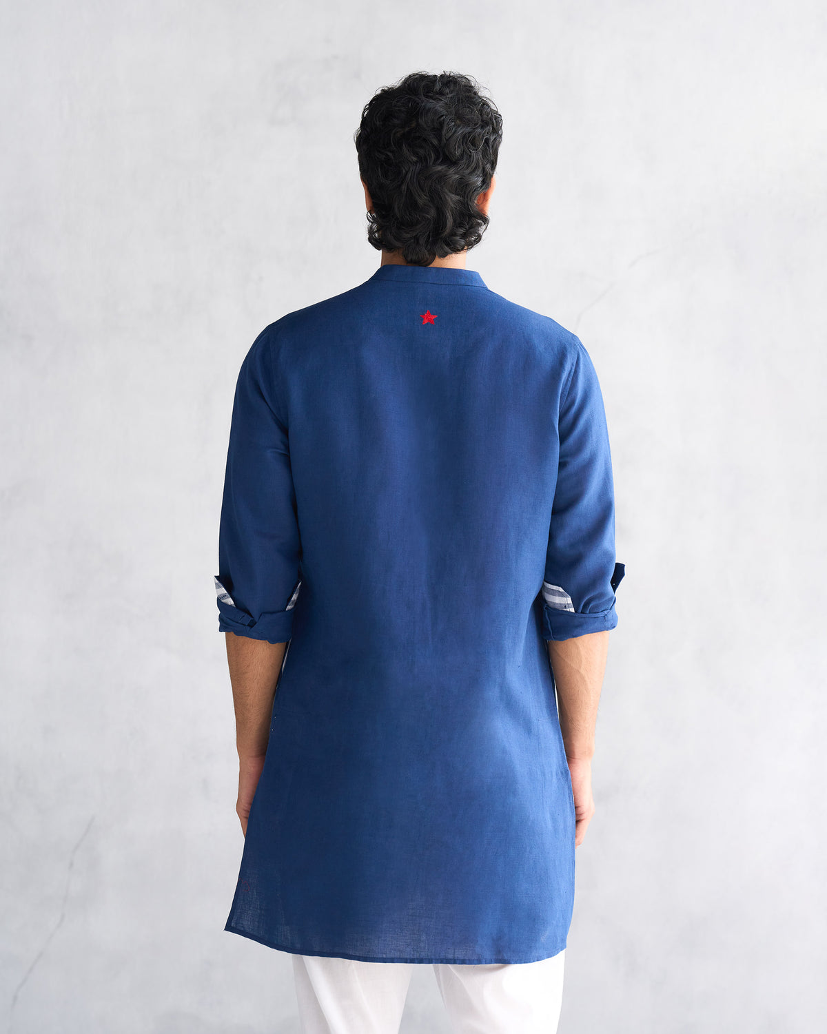 Back of a navy Chandni Chowk kurta with a red embroidered star.