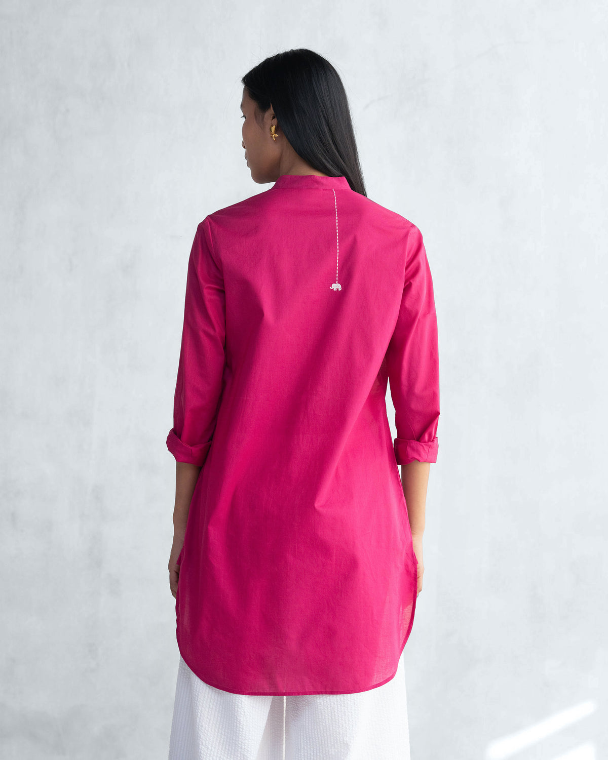 Back of a Basic Mid Length Kurta in berry with a tassel at the neck, worn by a person.