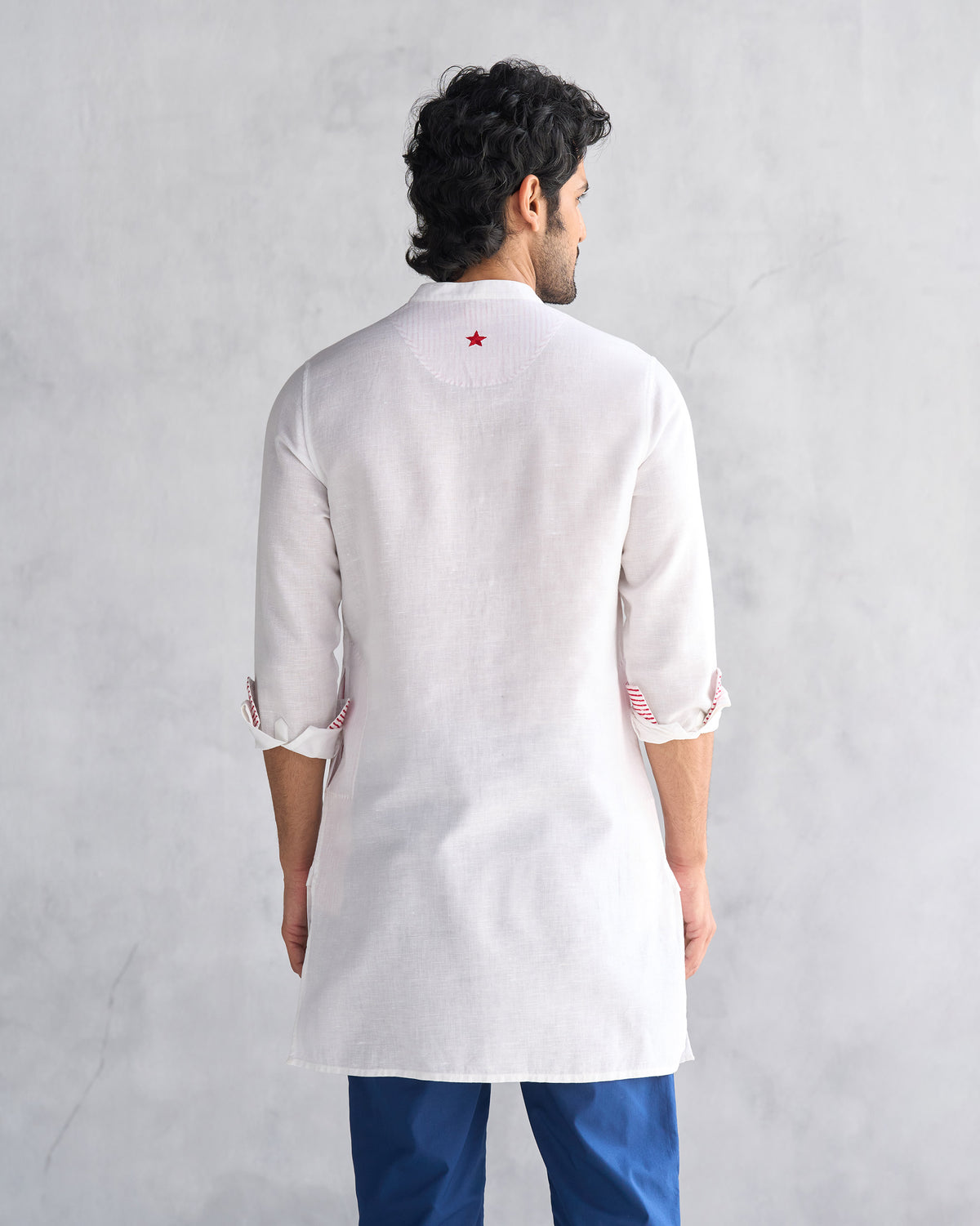 Back of a white Chandni Chowk kurta with a red embroidered star.
