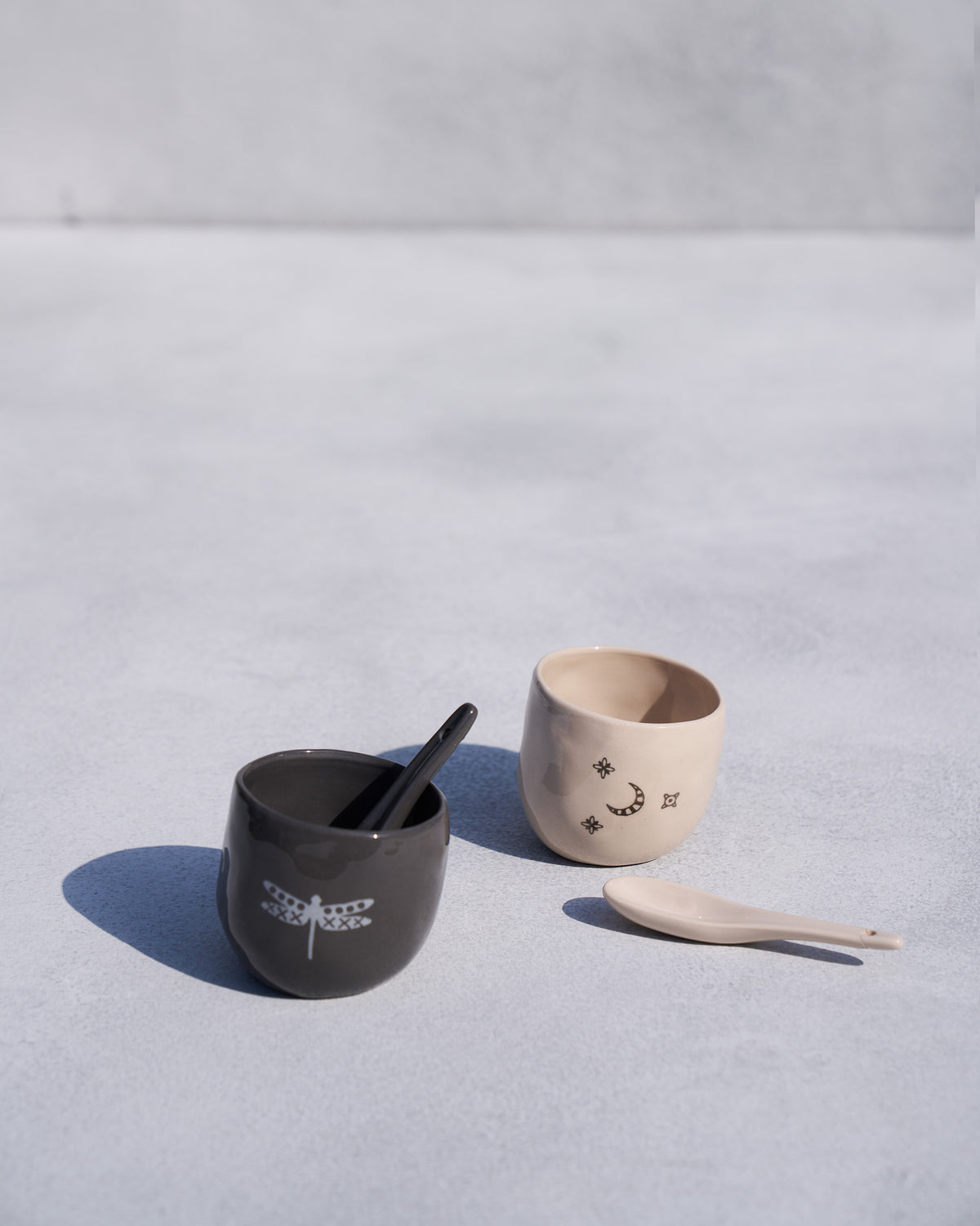 Taramandal salt and pepper set with ceramic spoons laid beside the pots.