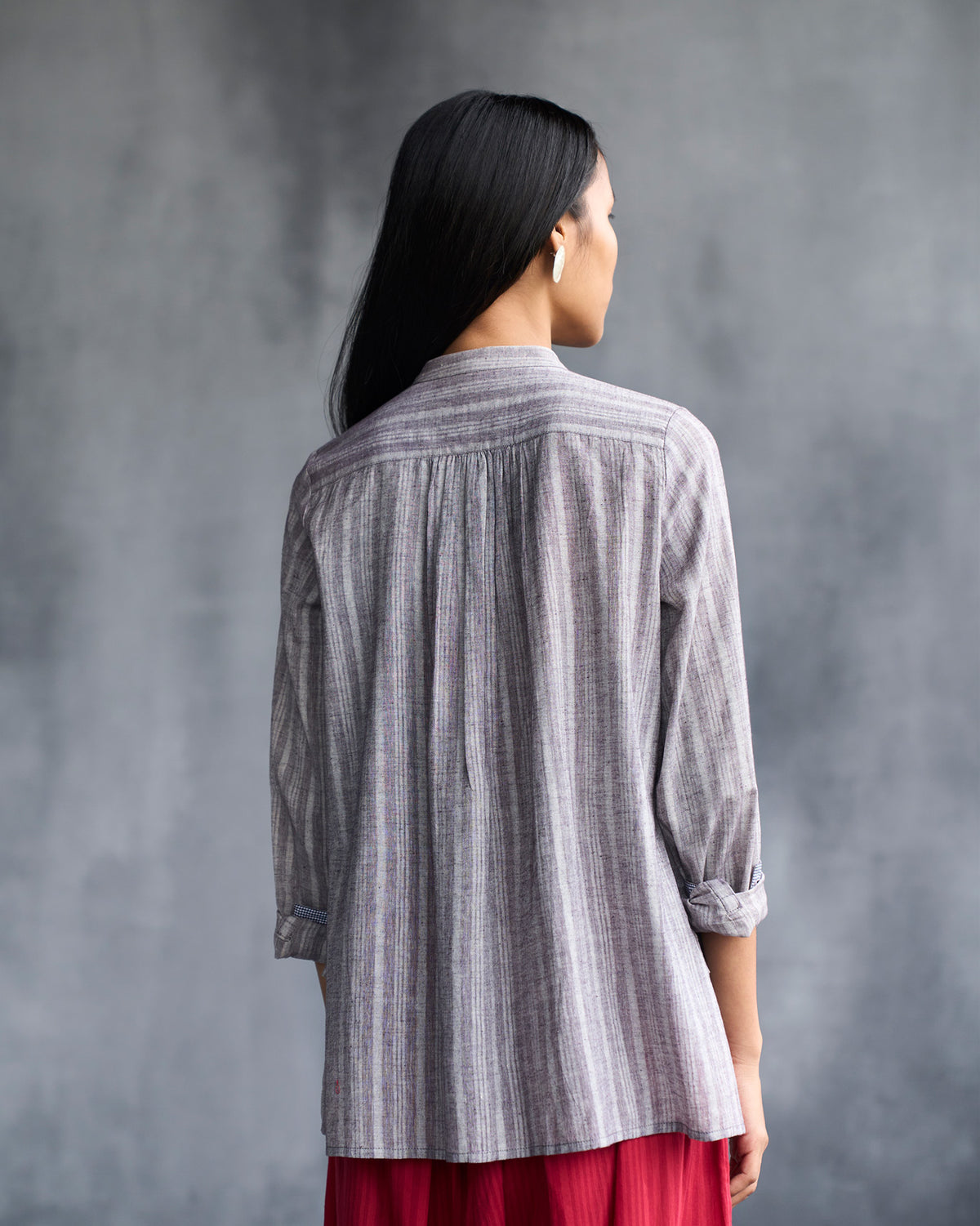 Back of a grey striped mandarin collar top with a gathered yoke.