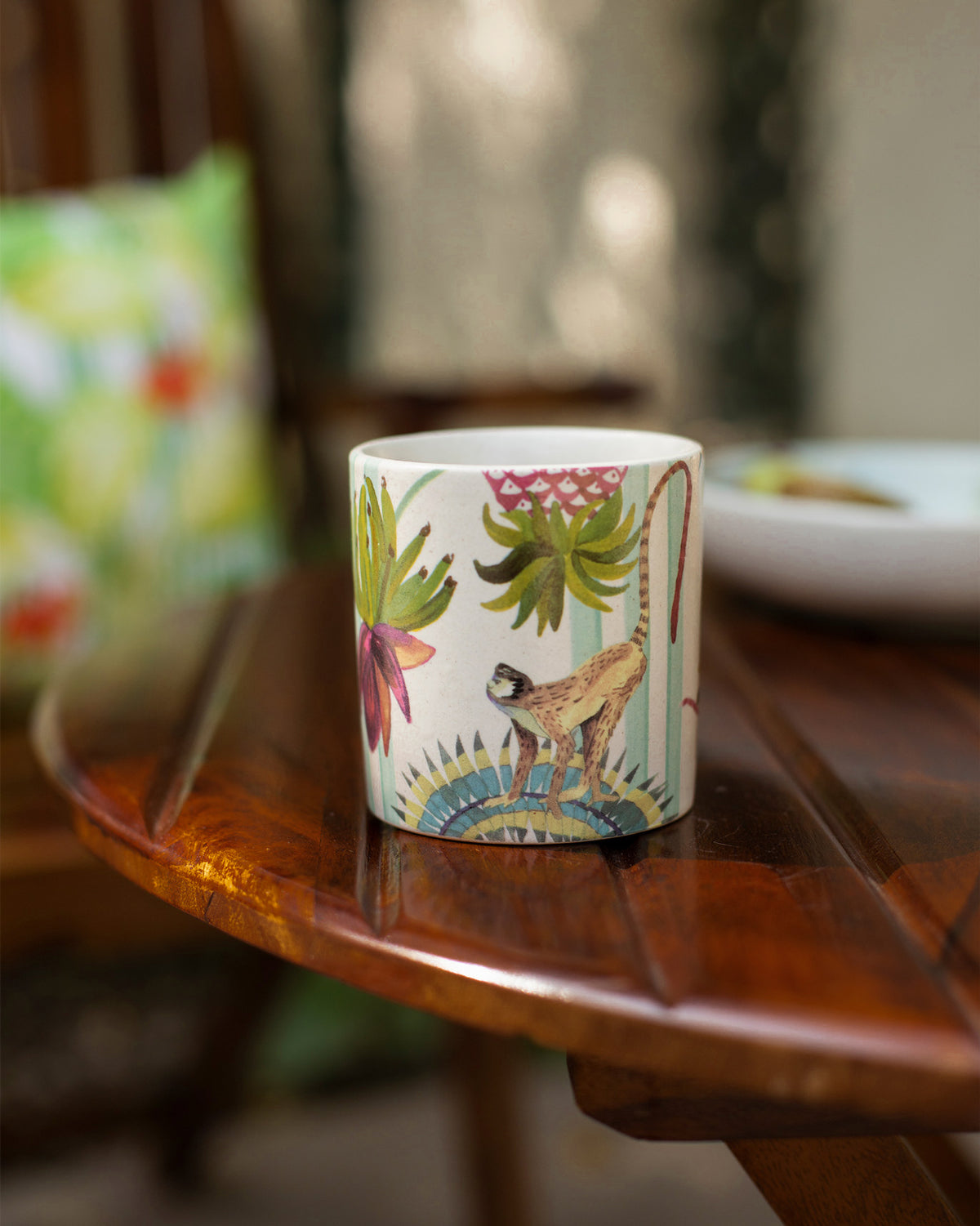 Ivory Mahi Mug on a wooden table, showing a monkey motif.