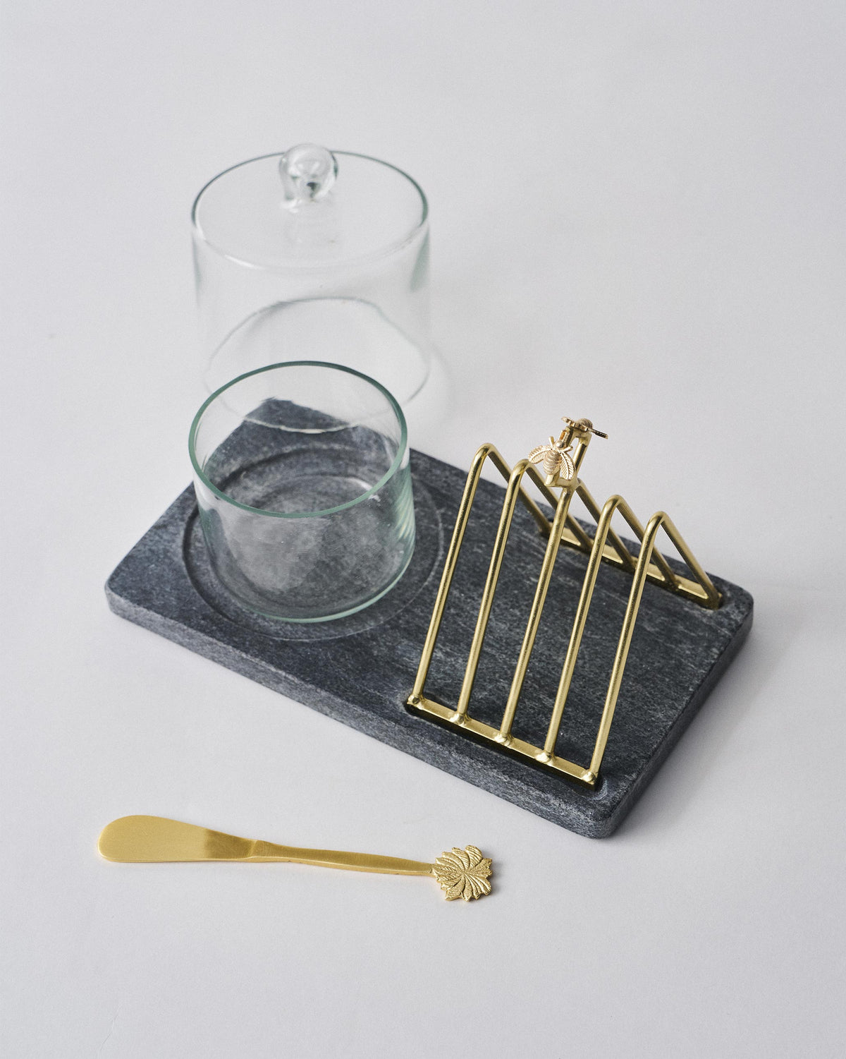 Mahi breakfast tray with open glass butter dish and gold spreader.
