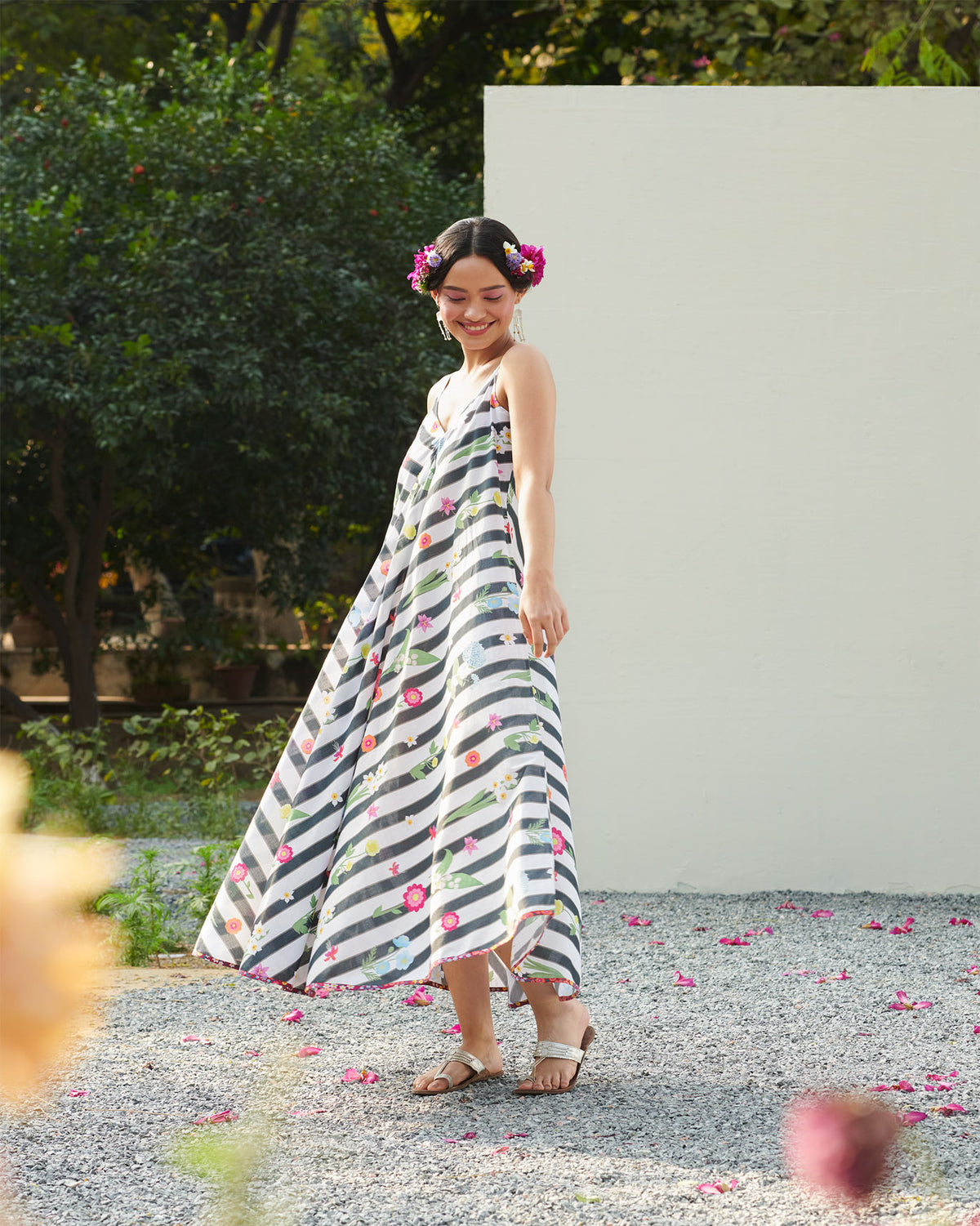 Person wearing a flowing black and white striped floral maxi dress.