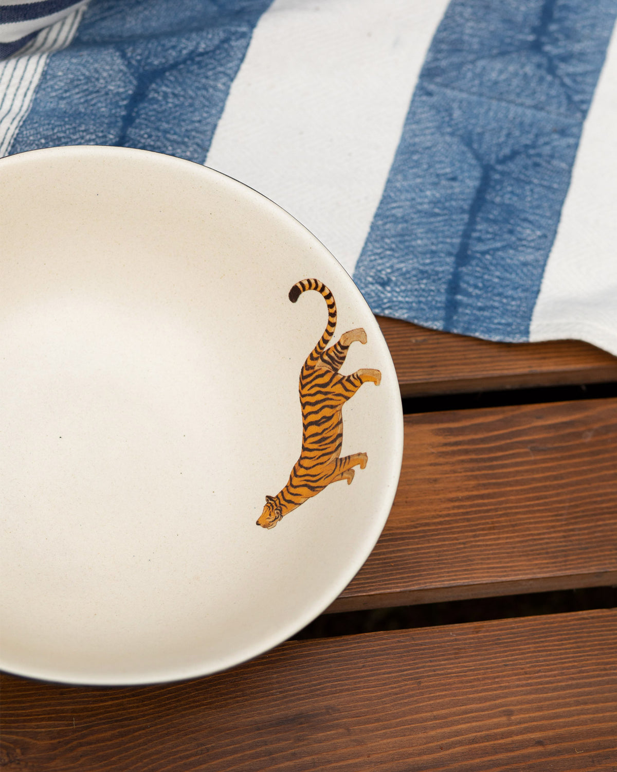 Close-up of an orange tiger print inside a cream Nadi curry bowl.